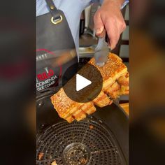 a person is using a knife to cut up some food on a panini grill