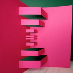 a pink and green wall with shelves on it