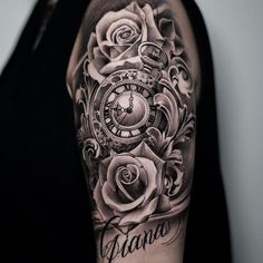 a black and white photo of a man's arm with an ornate clock and roses on it