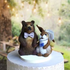 two small stuffed animals sitting on top of a cake