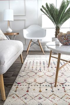 a living room with white furniture and a rug