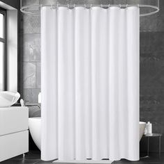 a white shower curtain in a black and white bathroom