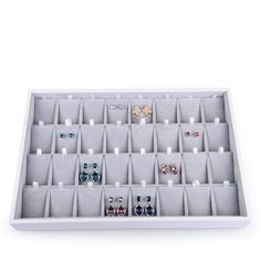 an assortment of earrings is displayed in a white display case on a table with the word fanxi written above it