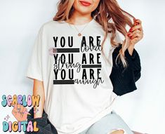 a woman wearing a t - shirt that says you are here, you are alright