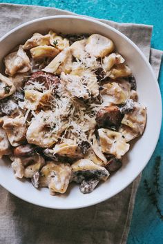 a white bowl filled with pasta and mushrooms