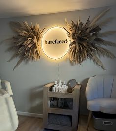 a hair salon with two chairs in front of the wall and a lighted sign above it