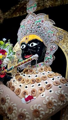 an elaborately decorated statue with donuts in it's mouth and headdress