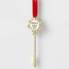 a golden key with a red ribbon hanging from it's side on a white wall