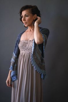 a woman in a dress and cardigan posing for the camera with her hand on her head