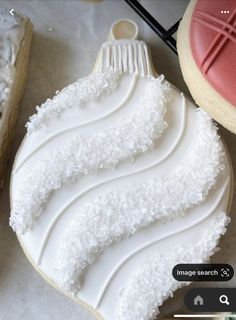 a cookie decorated with white frosting and icing on top of a table next to other cookies