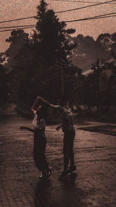 two people standing in the rain with an umbrella