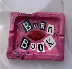 a pink plate with the words burn book on it