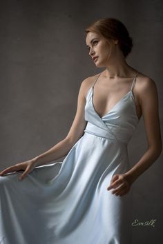 a woman in a white dress is posing for a photo with her hand on her hip