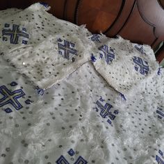 a white and blue blanket on top of a wooden headboard next to a night stand