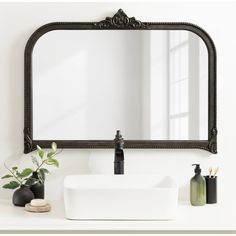 a bathroom sink with a mirror above it and soap dispenser next to it