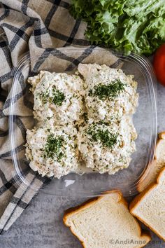 chicken salad in a plastic container next to sliced bread