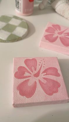 a pink flower painted on a piece of paper next to some toilet paper and other items