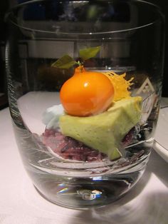 a glass bowl filled with food on top of a table