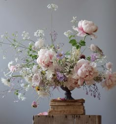 a vase filled with lots of flowers sitting on top of a wooden crate