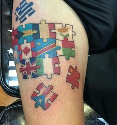 a person with a tattoo on their leg that has puzzle pieces in different colors and designs