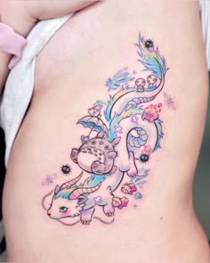 a woman's stomach with an artistic tattoo design on the side of her belly