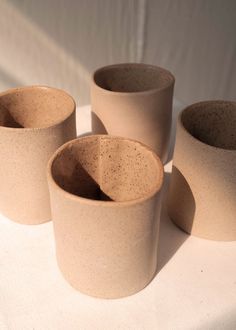 three brown cups sitting on top of a white table