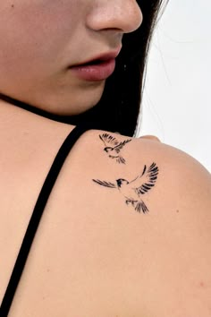 a woman with a bird tattoo on her shoulder