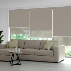 a living room filled with furniture and large windows covered in roller shade blind shades on the windows