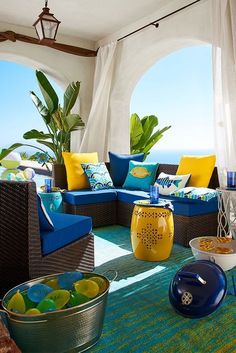 an outdoor living area with blue and yellow furniture