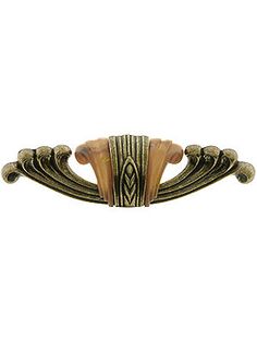 an antique brass drawer pull handle with carved designs on the front and sides, set against a white background