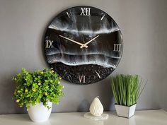 a clock that is on the side of a wall next to a potted plant