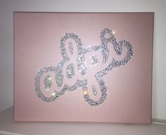 a pink card with silver sequins in the shape of an octopus on it