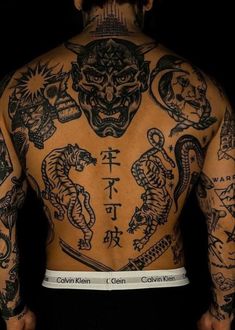 the back of a man's body with tattoos on his upper and lower half