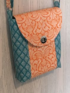 an orange and blue purse hanging on the wall