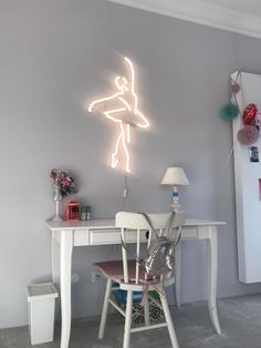 a desk with a chair and a neon sign on the wall in front of it