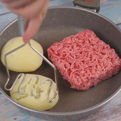 a hamburger patty being made in a frying pan with cheese and butter on the side