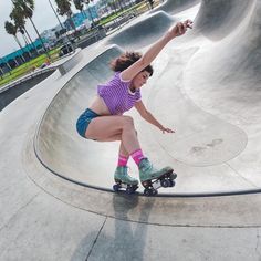 a woman riding a skateboard up the side of a ramp at a skate park