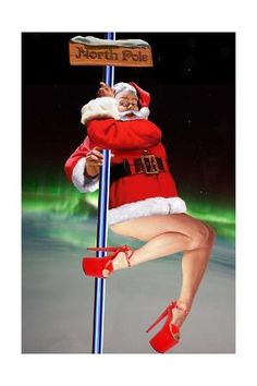 a woman dressed as santa claus hanging from a pole with a sign post in front of her