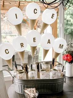 a bucket filled with ice cream sitting on top of a table next to a window