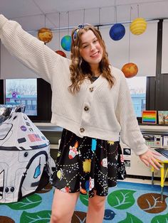 a young woman standing in front of a room filled with space themed decorations and toys