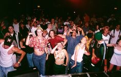 a group of people standing next to each other in front of a dj's booth