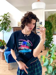 a woman taking a selfie with her cell phone in front of some potted plants