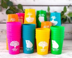 many different colored cups with trees on them