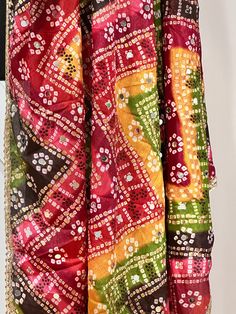 Experience the beauty of traditional Phulkari style with our Multicolor Dupatta. Made with a soft and luxurious silk finish, this dupatta features real mirror accents and stunning designs. Its heavy-weight construction makes it perfect for special occasions like Navaratri. Elevate your wardrobe with this must-have accessory. Approx 2.5 meters length Festive Katan Silk Dupatta With Traditional Drape, Traditional Multicolor Sharara With Motifs, Multicolor Silk Bandhani Choli, Multicolor Silk Choli With Bandhani Print, Multicolor Chinon Traditional Wear With Zari Work, Red Art Silk Dupatta With Mirror Work, Multicolor Chanderi Saree With Sheer Dupatta, Traditional Multicolor Motif Sharara, Multicolor Traditional Wear In Chinon