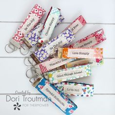 several keychains with different designs on them sitting next to each other in front of a white background