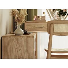 a wooden desk with a mirror and vase on it next to a white chair in front of a dresser