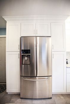 a stainless steel refrigerator in a white kitchen