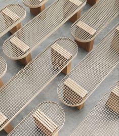 several wooden benches sitting on top of each other in front of metal grate dividers