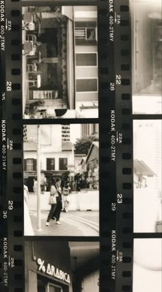 black and white photograph of people walking on the street in front of buildings with film strips