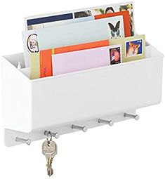 a white wall mounted mail holder with keys